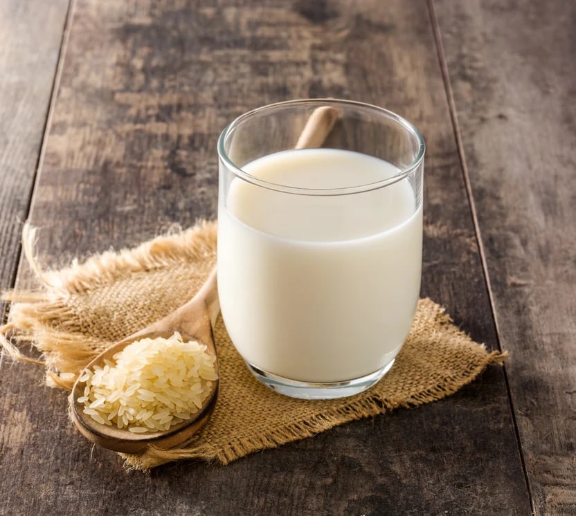 using rice milk in skincare (glass of rice milk with a spoon of rice)